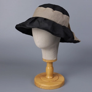 Close-up of wide brim sun hat with ruffles and beige ribbon on a model mannequin