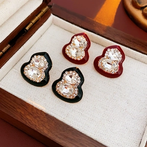 Detailed close-up of crystal-encrusted gourd stud earrings in red and black colors