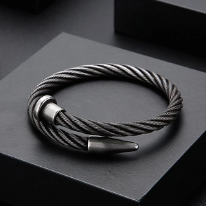 Industrial style dark gray steel cable nail bracelet with a textured metallic finish