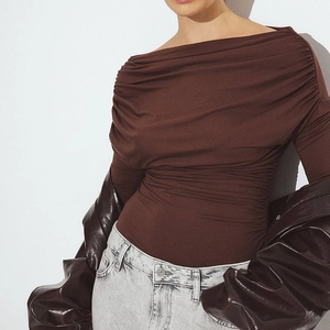 Detail of a brown off-the-shoulder slim fit top with elegant draping and pleated texture