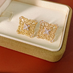 Close-up of vintage hollow geometric earrings with clear zircon in a velvet jewelry box