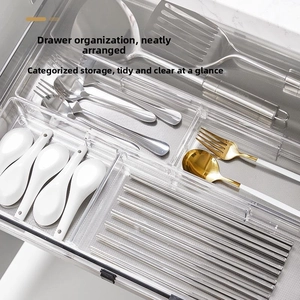 Macro detail of transparent drawer organizer showing cutlery dividers with cutlery set