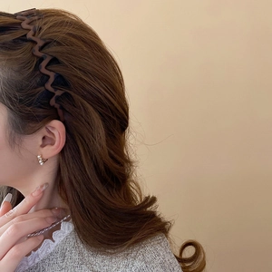 Detail view of leopard print wavy headband on model for a high top volume hairstyle