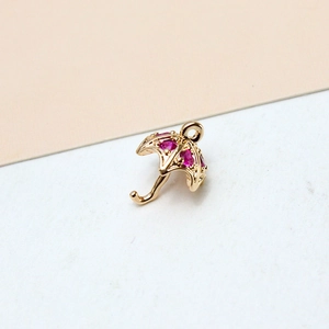 Detailed view of a gold-plated umbrella pendant with inlaid pink zircon crystals for DIY jewelry
