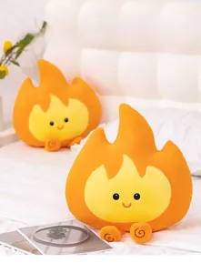 Detailweergave van pluche vlamkussens met geborduurde gezichten op een gezellig bed