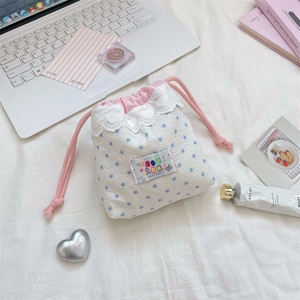 Close-up of white cotton drawstring bag with blue stars and delicate heart lace trim