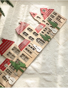 Detail of wooden Christmas house ornament with snowflake roof and snowman on white snow