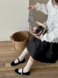 Gros plan de chaussettes tricotées pour femmes aux motifs variés dans un panier cadeau