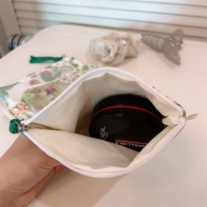 Detail view of floral cotton storage pouch with zipper showing internal makeup capacity