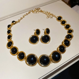 Detailed macro view of vintage resin pendant necklace and round gold earrings jewelry set