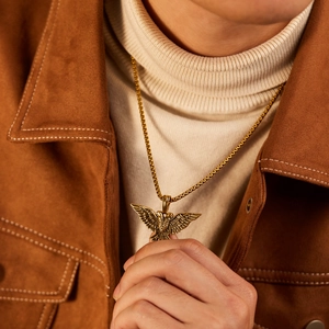 Men's punk eagle pendant necklace in gold stainless steel worn on a stylish male model