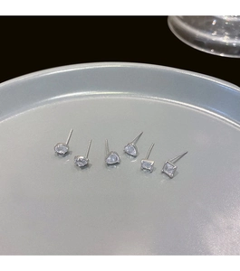 Close-up of 925 silver stud earrings set featuring zircon heart and geometric shapes