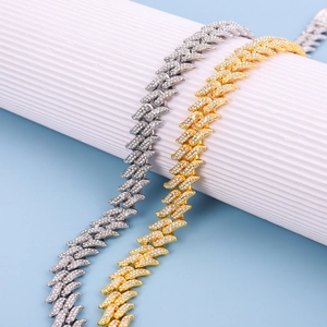 Detailed view of gold and silver cuban necklaces with iced-out diamond thorn flame pattern