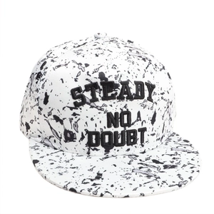 Close-up of black embroidery on white ink-splatter patterned flat brim hip hop cap