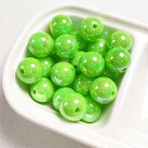 Close-up of 14mm green acrylic shell beads in a tray for DIY jewelry making