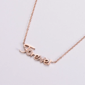 Rose gold Forever letter pendant necklace with sparkling cubic zirconia on light background