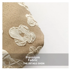 Close-up of light brown jacquard fabric with cream white abstract floral pattern detail