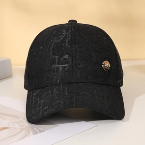 Detail of black sequined baseball cap featuring golden rhinestone badge and jacquard pattern