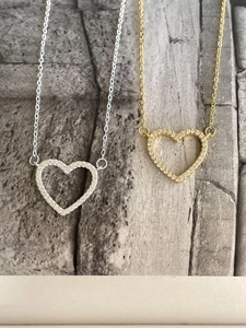 Close-up of gold and silver heart-shaped pendant necklaces with sparkling cubic zirconia