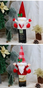 Detail view of gnome wine bottle covers in red and white knit for Christmas decor