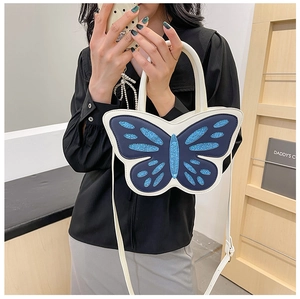 Detail of creative butterfly shaped handbag in blue glitter leather with shoulder strap