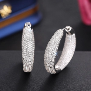Close-up of pavé set wide hoop earrings with sparkling white cubic zirconia stones