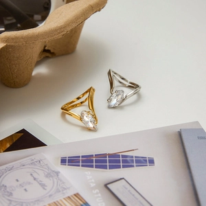 Macro detail of V-shaped 18k gold and silver rings with marquise cut zircon stones