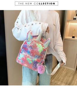 Detail of sequin unicorn backpack with silver horn and pink fluffy pom-pom keychain
