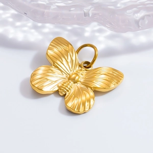 Macro detail of a polished 18K gold-plated butterfly pendant with crystal accents