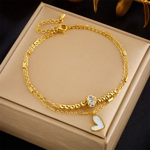 Double-layered gold chain anklet with heart pendant and crystals on jewelry box