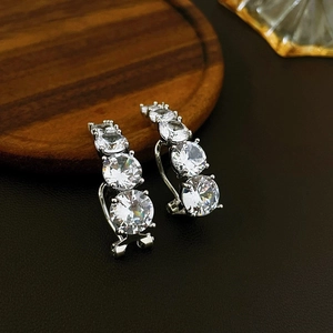 Gros plan détaillé de boucles d'oreilles géométriques en argent avec zircons brillants