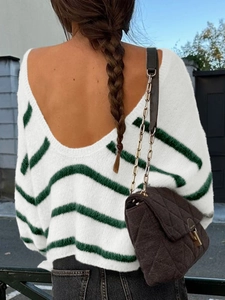 Back view of women's white knit sweater with green stripes and open back design
