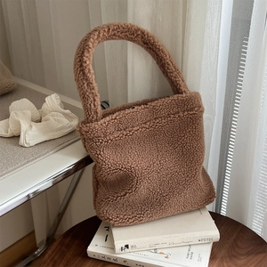 Detailed view of brown plush faux fur tote bag texture on cozy lifestyle background