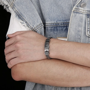 Close-up of retro engraved skull bracelet in titanium steel on model with denim jacket