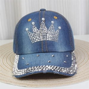 Détail de casquette en jean avec motif couronne en strass et accents de perles