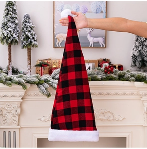 Detailed view of red and black plaid Christmas hat with soft white plush trim and pom-pom