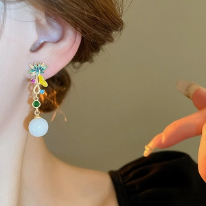 Boucles d'oreilles chinoises avec fleurs en émail et perles portées par un mannequin