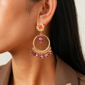 Detail of vintage bohemian drop earrings with red and purple beads on model