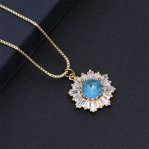 Macro shot of gold sunflower necklace featuring a blue gemstone center and zircon petals