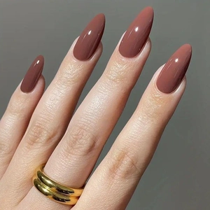 Glossy terracotta brown long almond press-on nails on hands with a high-shine finish