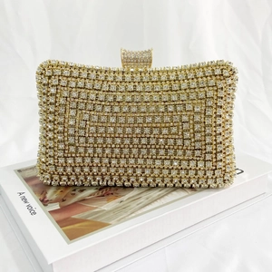 Close-up of sparkling clear rhinestones on light gold hard-shell evening clutch bag