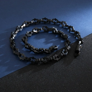 Macro detail of black matte geometric chain necklace with lobster clasp for men
