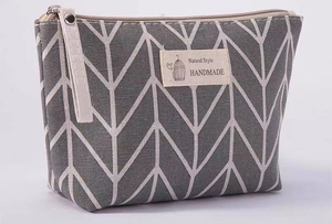 Close-up of geometric canvas makeup bag with Natural Style label and wrist strap