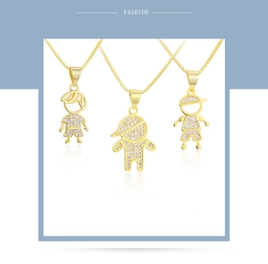 Detailed macro view of three 18k gold boy-shaped pendants with shimmering zircon micro-inlays