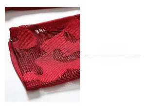 Détail du poignet en maille ajourée rouge montrant le motif de tissage fin