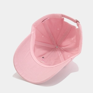 Detail of pink cotton baseball cap showing internal stitching and adjustable metal buckle