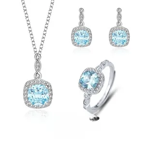 Detail of S925 silver jewelry set featuring square light blue stones and halo diamonds