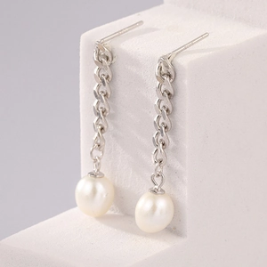 Detailed macro view of S925 silver needle drop earrings with elegant white hanging pearls