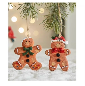 Detail of gingerbread man Christmas tree ornaments with snow and bokeh light backdrop
