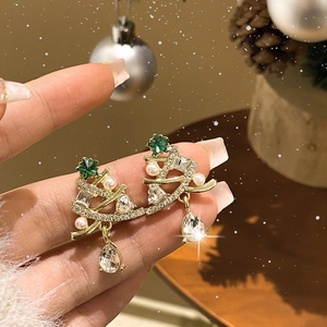 Detail of Christmas tree earring with gold metal, pearls, and green star rhinestone